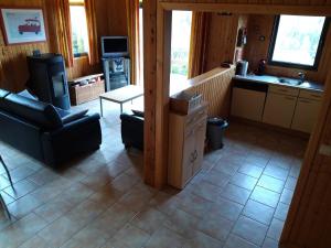 uma sala de estar com um sofá e uma cozinha em Chalet Bonne Humeur em Houffalize