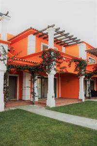 an orange and white building with flowers on it at Delux Tavira I in Tavira