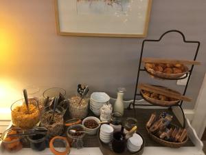 einen Tisch mit einem Haufen Essen und anderen Dingen in der Unterkunft Hôtel du Parc in Montpellier