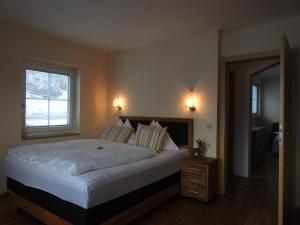 ein Schlafzimmer mit einem großen Bett und einem Fenster in der Unterkunft Hotel Tauernglöckl in Obertauern