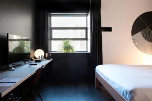 a bedroom with a bed and a window at Mabi City Centre Hotel in Maastricht
