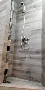 um chuveiro na casa de banho com piso em madeira em Jurgis Guest house em Kaunas