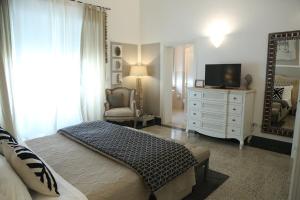 a bedroom with a bed and a dresser with a television at Palazzo Bignami in Lecce