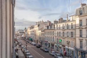 - une vue sur une rue de la ville avec des voitures et des bâtiments dans l'établissement Greeter-Le Petit Versailles, à Versailles