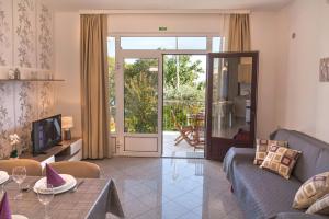 a living room with a couch and a sliding glass door at Apartment Villa Lidija in Lovran