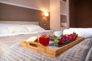 a tray of fruit and a drink on a bed at Al Vicolo tre in Sassari