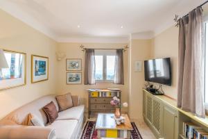 Una sala de estar con un sofá y un televisor. en Orangerie St Paul, en Saint-Paul-de-Vence