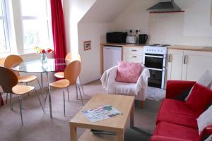 a living room with a table and a kitchen at The Garden Apartment in Dunino