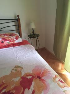 a bedroom with a bed with a flower blanket at House Kupina in Gdinj