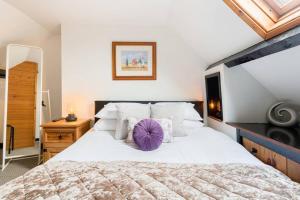a bedroom with a large bed with a purple pillow at Fergies Canal Side Cottage in Warwick