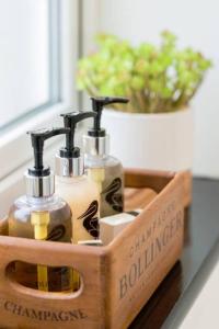 a wooden holder with three bottles of soap at Fergies Canal Side Cottage in Warwick