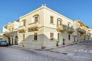 um grande edifício branco no lado de uma rua em Ta Joseph em Xewkija