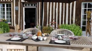 una mesa de madera con platos de comida. en La Charretterie, en Bacqueville-en-Caux