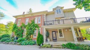 a large house with a balcony on top of it at Norfolk Guest House Inn in Guelph