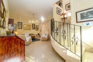 a living room with a spiral staircase in a house at Ta Joseph in Xewkija