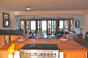 a kitchen with a stove and a living room at Villa Paradise on the Ocean in Gazija