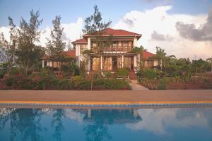 een huis met een zwembad ervoor bij Villa Paradise on the Ocean in Gazija