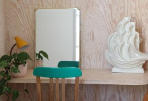 a green chair sitting on a shelf in front of a mirror at Le Petit Rivage in La Charité-sur-Loire