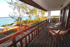 een veranda met stoelen en uitzicht op de oceaan bij Villa Paradise on the Ocean in Gazija