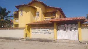 新維索薩的住宿－Residencial Santos，黄色房子前面有标志