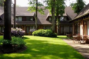 una casa con un patio con mesas y sillas en Van der Valk Hotel Hilversum/ De Witte Bergen, en Hilversum