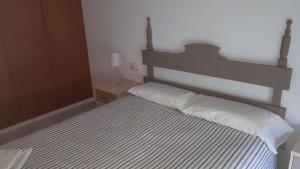 een slaapkamer met een groot bed met witte kussens bij La Rambleta in L'Ametlla de Mar
