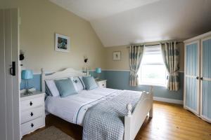 a bedroom with a white bed and a window at Green Meadow Farm Holiday Homes in Wicklow