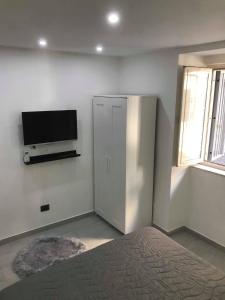 une chambre avec une télévision à écran plat au mur dans l'établissement Nel Cuore di Napoli, à Naples