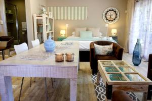 a living room with a bed and a dining room table at Milly's Touch Studios in Roodepoort