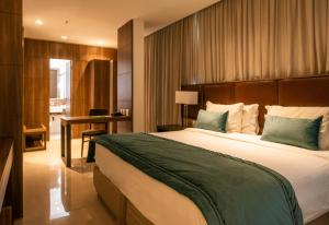 1 dormitorio con 1 cama grande y escritorio en Américas Barra Hotel, en Río de Janeiro