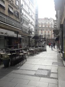 an empty city street with tables and chairs and buildings at Apartment Ema in Belgrade
