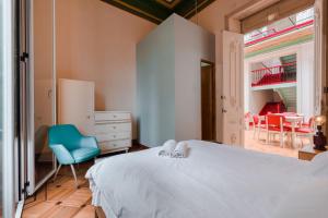 a bedroom with a white bed and a blue chair at Hostal R10 in Bogotá