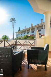 a patio with chairs and a view of a building at Colina Verde Resort in Moncarapacho