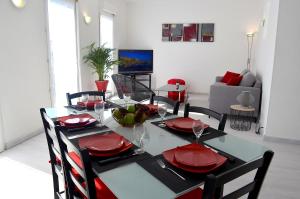 uma sala de jantar com uma mesa com pratos vermelhos em Duplex Liberté Plein Centre em Saint-Raphaël