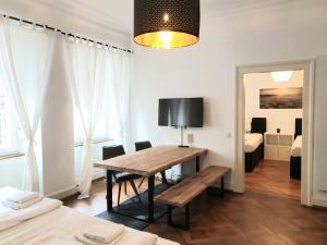 ein Esszimmer mit einem Tisch und ein Schlafzimmer in der Unterkunft StayInn "Heart of the City" Suite in Freiburg im Breisgau