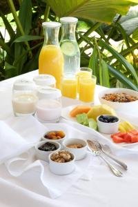 a white table topped with bowls of food and juice at Cobblers Cove - Barbados in Saint Peter