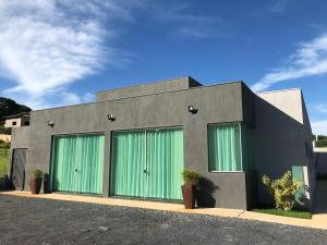 a building with green doors on the side of it at POUSADA LIMAS SUITES in Capitólio