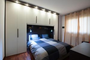 1 dormitorio con 1 cama y armarios blancos en CaseOspitali - CASA I GIARDINI - bilocale a pochi passi dal San Raffaele, en Vimodrone