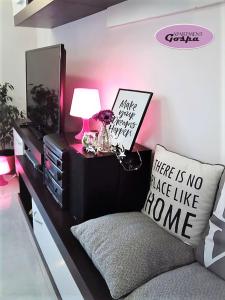 a living room with a couch and a dresser with a lamp at Apartment Gospa in Pula