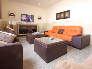 a living room with an orange couch and a tv at AReH Apartamentos in Barbate