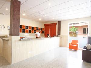 a man standing at a counter in a hospital lobby at AReH Apartamentos in Barbate