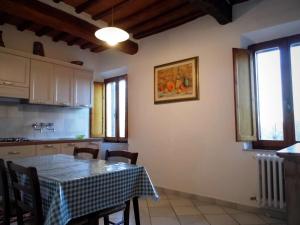 una cucina e una sala da pranzo con tavolo e sedie di CASA SERENA a Montepulciano