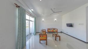 sala de estar con mesa, sillas y ventana en Ocean Breeze Apartment Colombo, en Colombo
