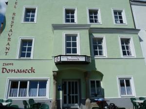 a green building with a sign in front of it at Hotel-Restaurant zum Donaueck Mauthausen in Mauthausen