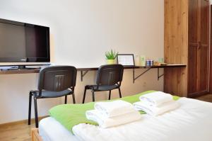a bedroom with two chairs and a bed with a television at WenderEDU Business Center in Wrocław