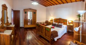 a bedroom with a bed in a room with wooden floors at Quinta das Bolas in Ponta Delgada
