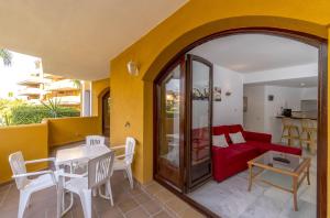 een woonkamer met een rode bank en een tafel bij Apartmento Carla Punta Prima in Torrevieja