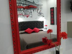 specchio rosso con letto in camera di Hostal Lauria a Madrid