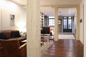 een woonkamer met een bank en een tafel bij Casco Viejo Comodidad y elegancia by Urban Hosts in Bilbao