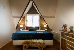 ein Schlafzimmer mit einem blauen Bett und einem Fenster in der Unterkunft Haarlem Hotel Suites in Haarlem